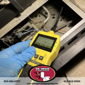 Plumber using acoustic leak detection tools in San Francisco home to locate hidden pipe issues