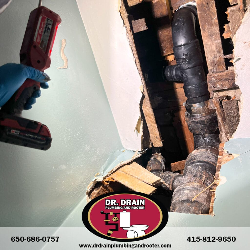 Technician repairing jammed garbage disposal under kitchen sink in SF home